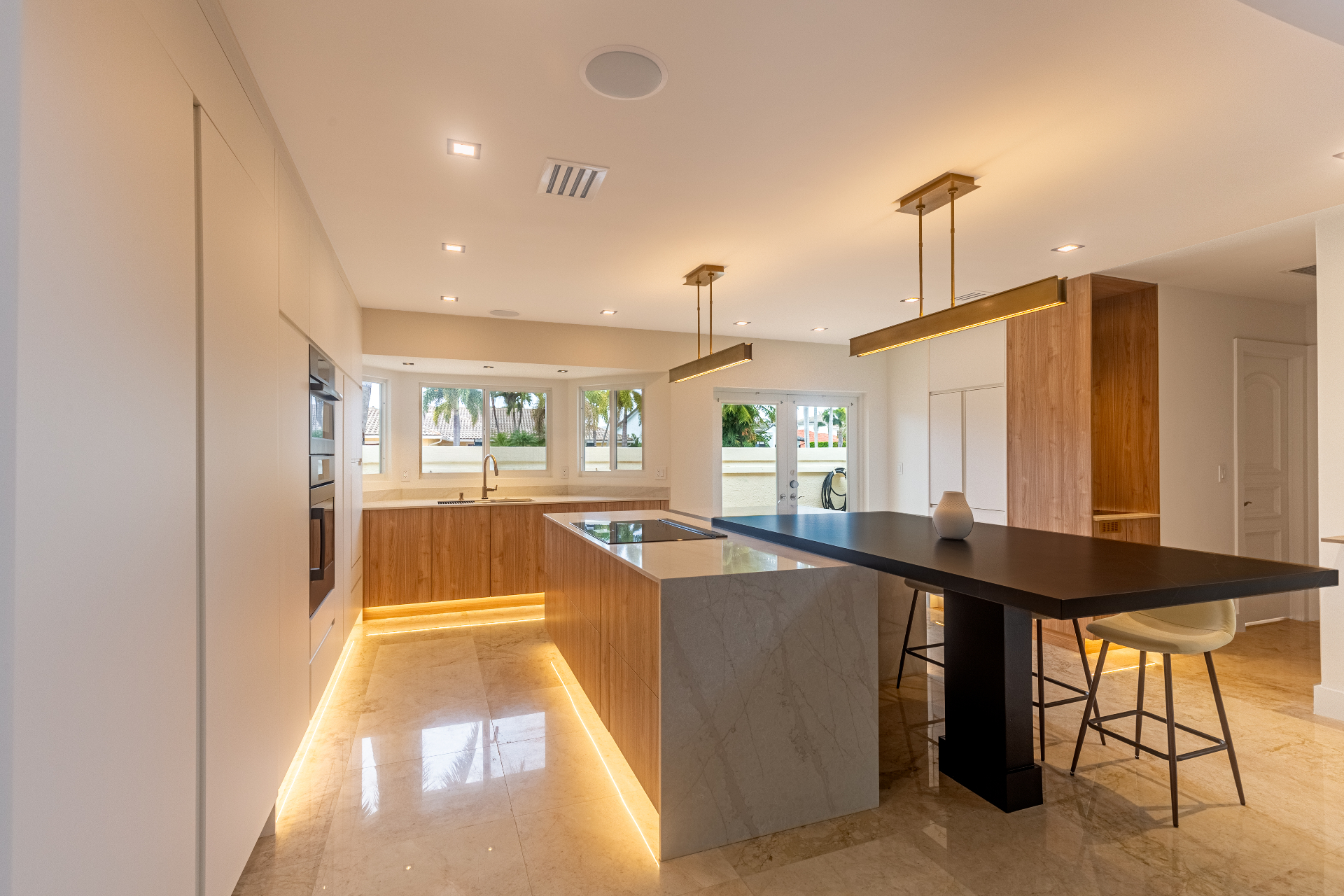 Kitchen overview with black bar-height table and stone island