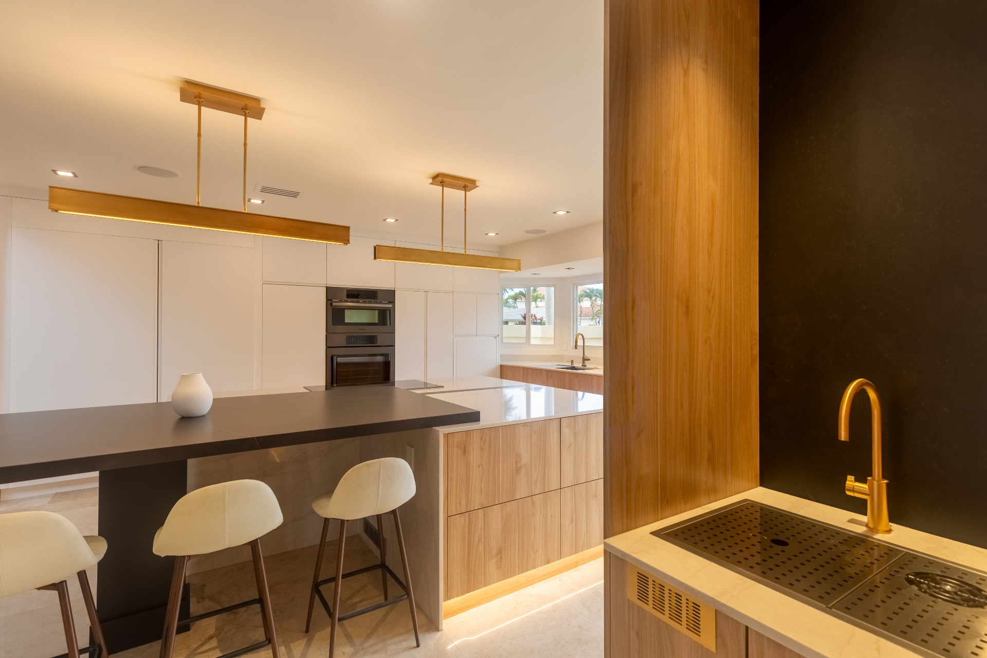 Custom kitchen wet bar with brass fixtures and walnut paneling